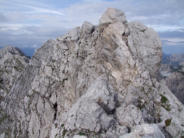 Foto: Datzi / Wandertour / Wandertour zum Jalovec mit sehr schwieriger Gratüberschreitung an der slowenischen u. Italienischen Grenze / In der Bildmitte sieht man das Band das ca. 30 Grad abfällt und 30m lang ist. (Bis in die Mitte des Bandes hat man ein Seil das nur 1 mal befestigt ist - links davon der Abruch der senkrecht nach unten geht) / 15.08.2011 18:07:45